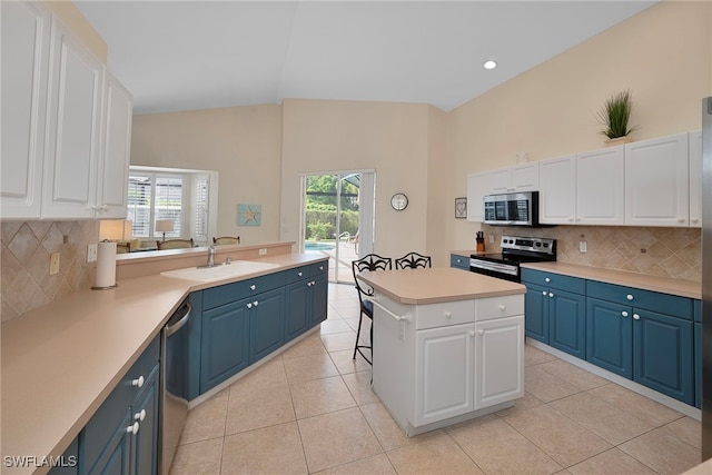 kitchen with blue cabinetry, stainless steel appliances, and white cabinets