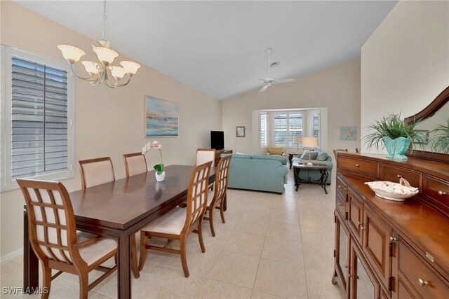 dining area featuring light tile patterned floors, ceiling fan with notable chandelier, and vaulted ceiling