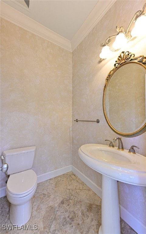 bathroom featuring toilet, sink, and crown molding