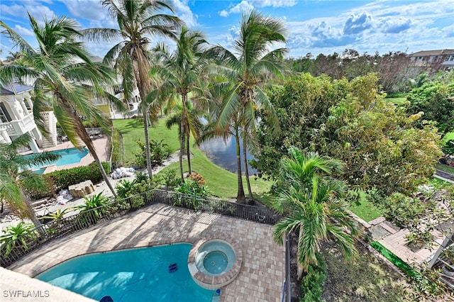 view of swimming pool with a yard, a water view, an in ground hot tub, and a patio area