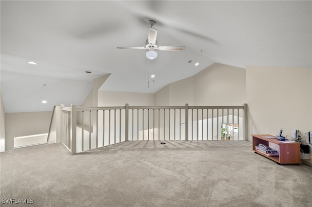 interior space with ceiling fan, vaulted ceiling, and carpet flooring