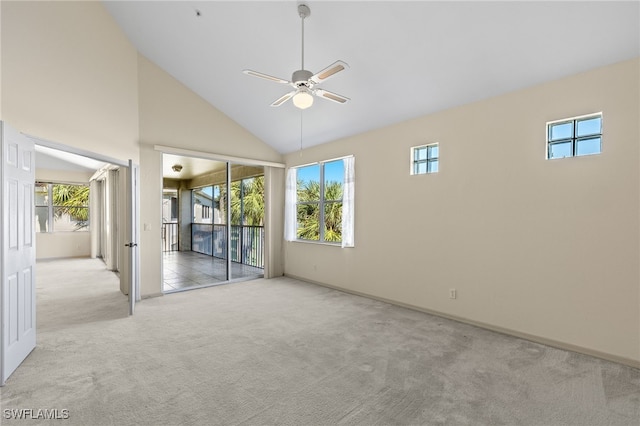 spare room with light carpet, ceiling fan, and high vaulted ceiling