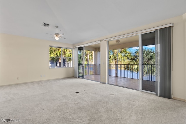 spare room with ceiling fan, light colored carpet, and vaulted ceiling