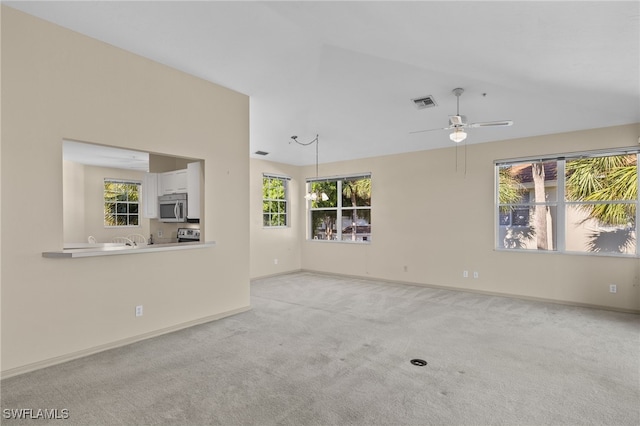 unfurnished living room featuring light carpet, ceiling fan, and a healthy amount of sunlight