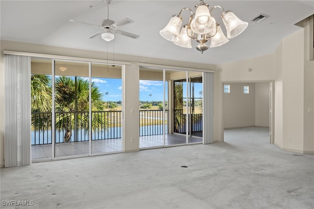 empty room featuring carpet floors, ceiling fan with notable chandelier, and a water view