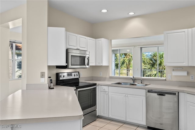 kitchen with white cabinets, stainless steel appliances, sink, and kitchen peninsula