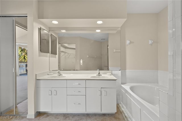 bathroom with a bath, vanity, and tile patterned floors