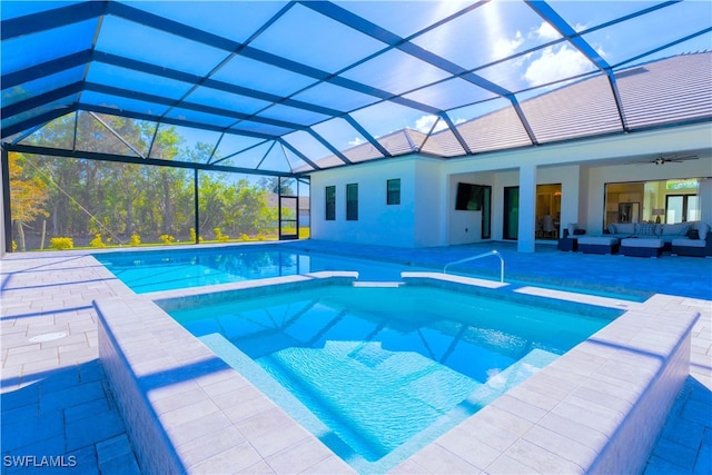 view of swimming pool featuring glass enclosure, ceiling fan, and a patio area