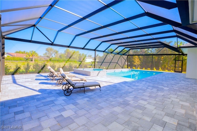 view of swimming pool with a patio, glass enclosure, and an in ground hot tub