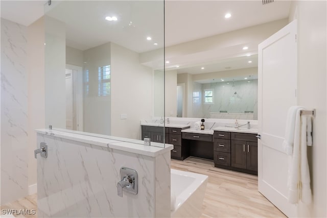 bathroom with wood-type flooring, vanity, and independent shower and bath