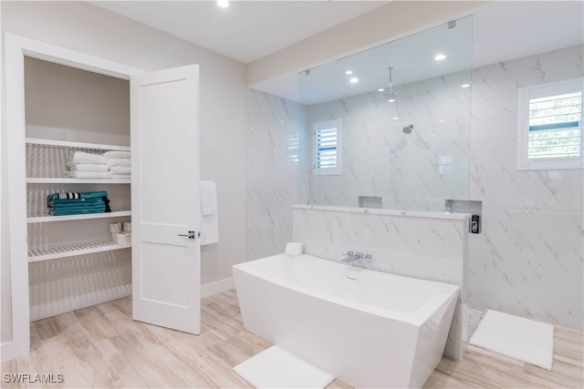 bathroom with independent shower and bath and hardwood / wood-style floors