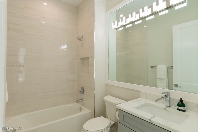 full bathroom with tiled shower / bath, vanity, and toilet