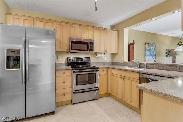 kitchen with sink, light tile patterned floors, stainless steel appliances, and light brown cabinetry