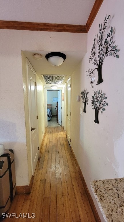 hall featuring ornamental molding and light hardwood / wood-style flooring