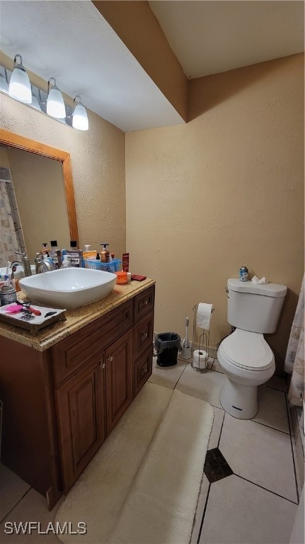 bathroom with tile patterned flooring, vanity, and toilet