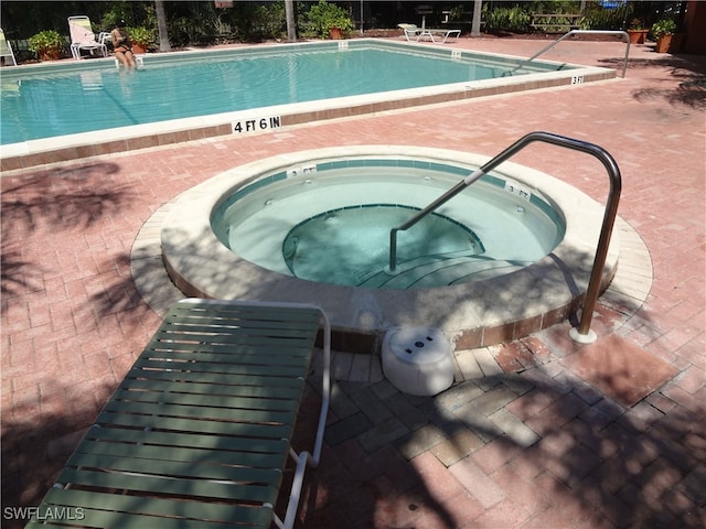 view of pool with an in ground hot tub and a patio