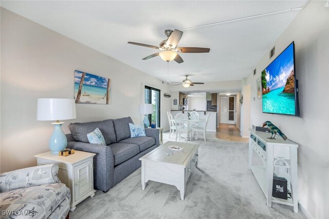 living room featuring ceiling fan and light carpet