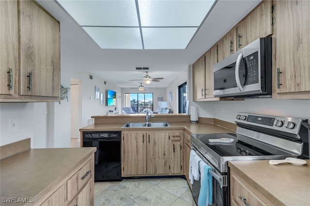 kitchen featuring appliances with stainless steel finishes, light tile patterned flooring, kitchen peninsula, ceiling fan, and sink