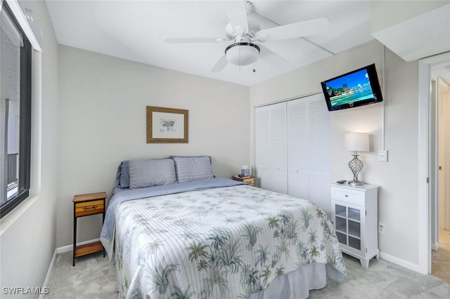 carpeted bedroom featuring a closet and ceiling fan