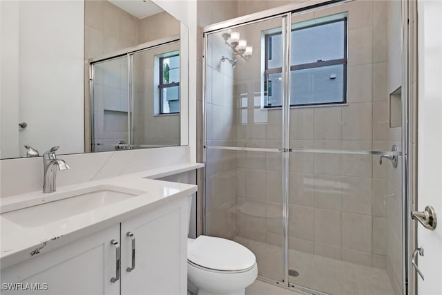 bathroom featuring walk in shower, vanity, toilet, and plenty of natural light