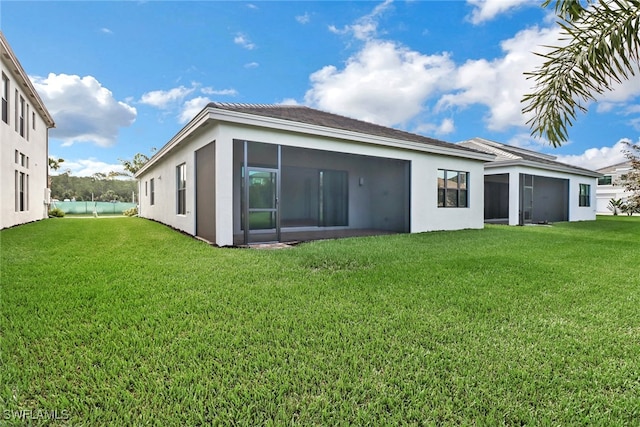 back of house featuring a yard and a sunroom