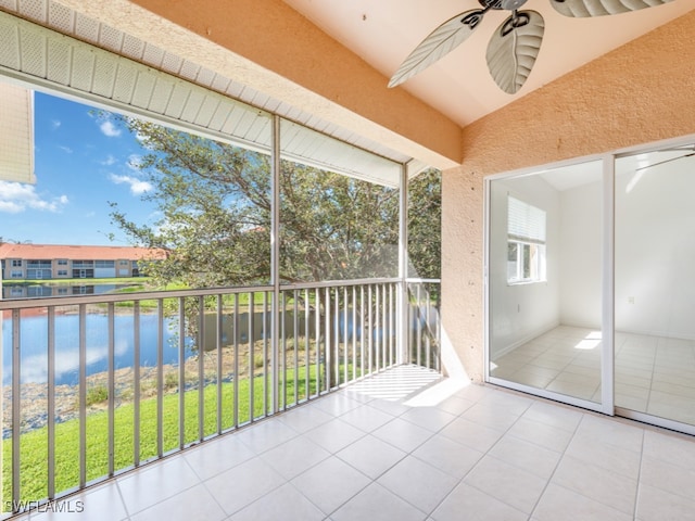 unfurnished sunroom with a water view, plenty of natural light, and ceiling fan