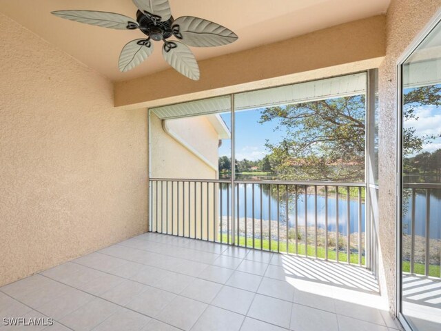 sunroom / solarium with ceiling fan and a water view