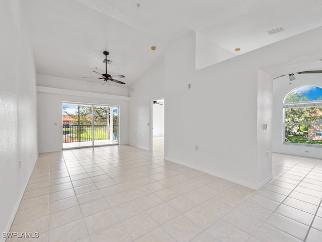 empty room with a wealth of natural light, light tile patterned floors, and ceiling fan