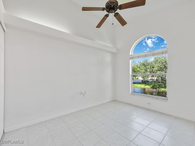 tiled empty room with a high ceiling and ceiling fan