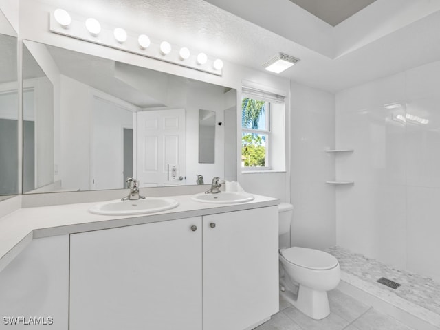 bathroom featuring tile patterned floors, walk in shower, a textured ceiling, vanity, and toilet