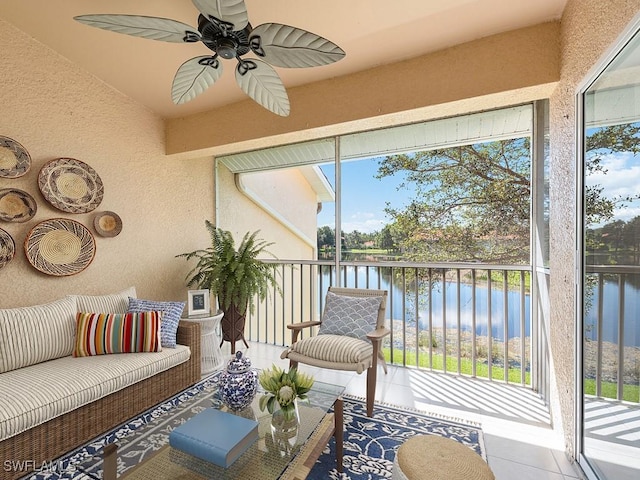 sunroom featuring ceiling fan and a water view