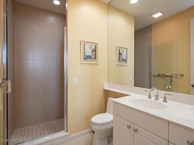 bathroom with tile patterned floors, a shower with door, vanity, and toilet