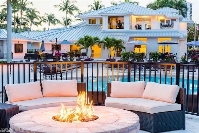 455 Cove Tower Dr Unit 1704, Naples, FL 34110 - exterior space with a balcony, an outdoor living space with a fire pit, and an outdoor pool
