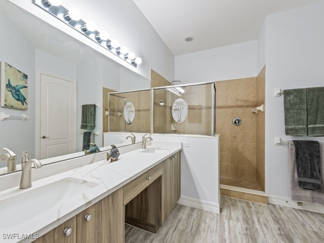 bathroom featuring a tile shower, hardwood / wood-style flooring, and vanity