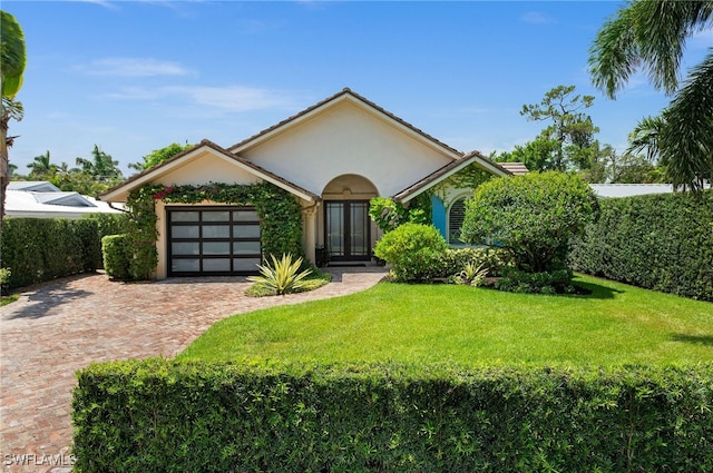 ranch-style home with a garage and a front lawn