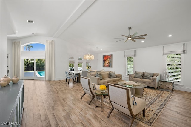 living room featuring ceiling fan with notable chandelier, vaulted ceiling, and light hardwood / wood-style floors