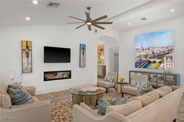 living room with ceiling fan, vaulted ceiling with beams, and hardwood / wood-style flooring