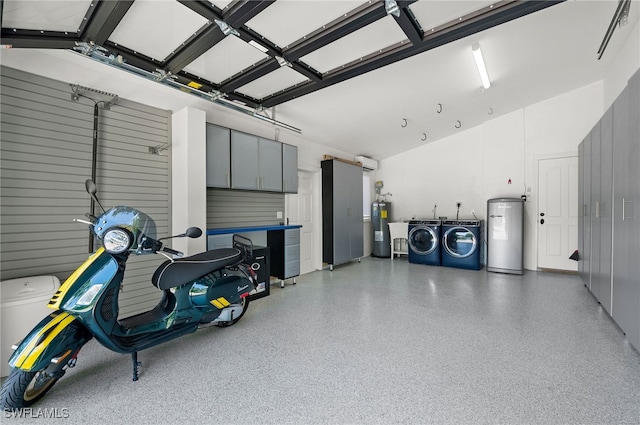 garage featuring electric water heater, water heater, and independent washer and dryer