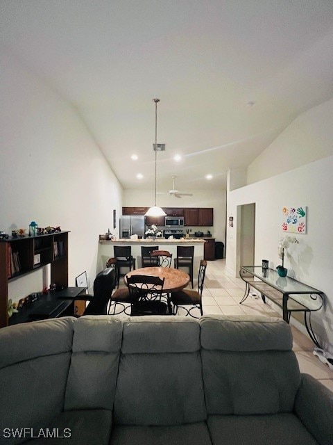 living room with light tile patterned floors and vaulted ceiling