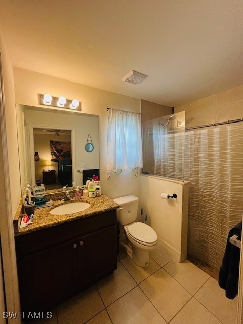 bathroom featuring vanity, a shower with curtain, toilet, and tile patterned flooring