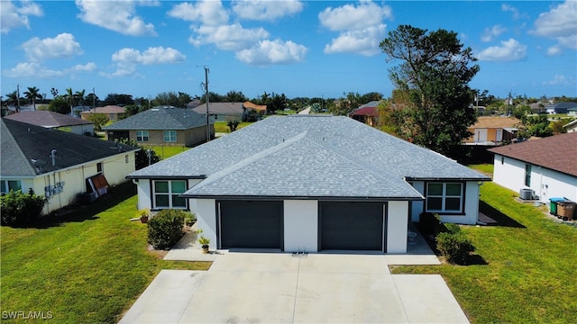 view of front of house with a front lawn, central AC, and a garage