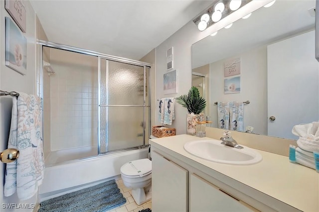 bathroom with visible vents, toilet, combined bath / shower with glass door, vanity, and tile patterned floors