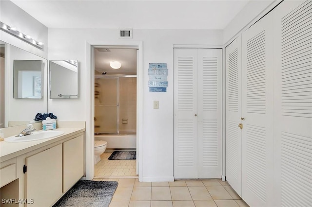 full bath featuring toilet, visible vents, vanity, a closet, and tile patterned floors