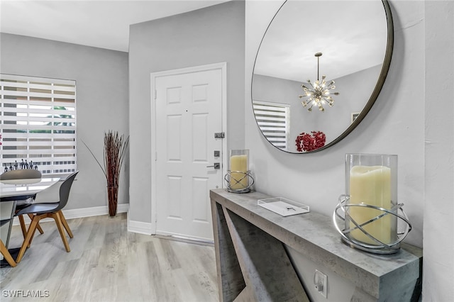 entrance foyer with an inviting chandelier and light wood-type flooring