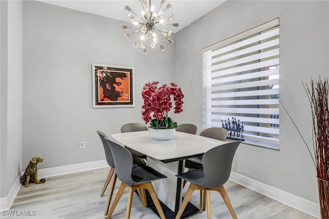 dining room with light hardwood / wood-style flooring and a notable chandelier