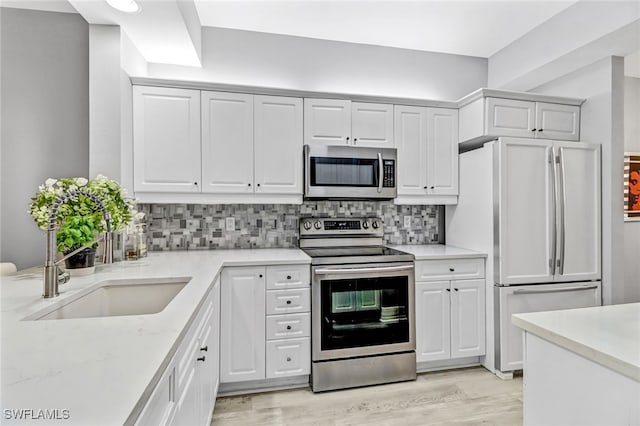 kitchen featuring stainless steel appliances, backsplash, and white cabinetry