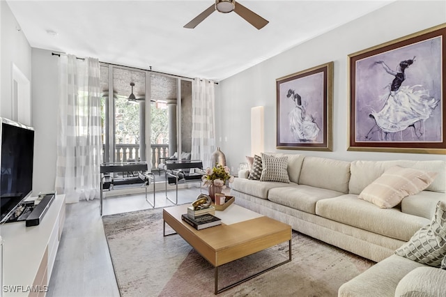 living room featuring ceiling fan and hardwood / wood-style flooring