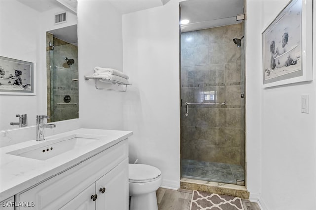 bathroom featuring walk in shower, vanity, toilet, and hardwood / wood-style flooring