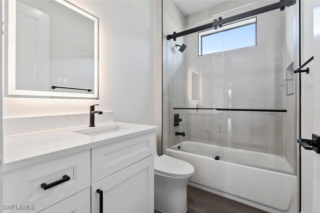 full bathroom featuring enclosed tub / shower combo, vanity, toilet, and wood-type flooring