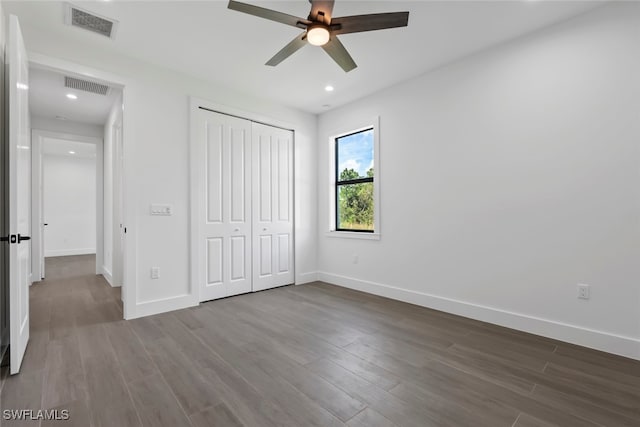 unfurnished bedroom with ceiling fan, hardwood / wood-style flooring, and a closet